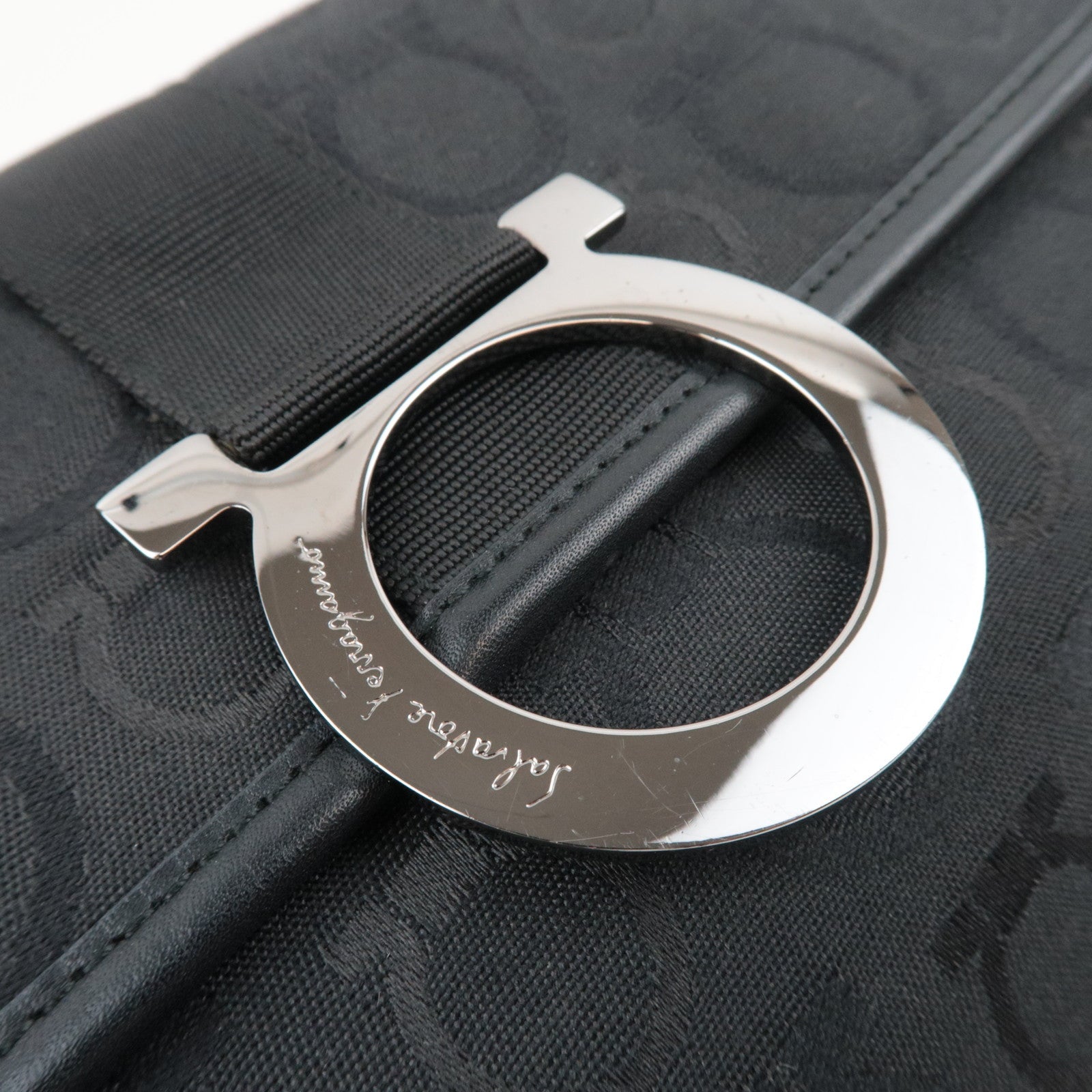 Ferragamo Gancini Shoulder Bag Canvas Leather Black close-up of metal logo detail on black fabric